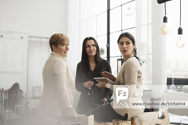 Businesswomen discussing while standing in office