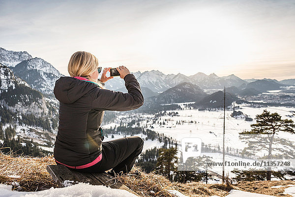Junge Wanderin fotografiert Allgäuer Alpen auf Smartphone  Bayern  Deutschland