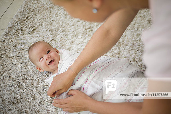 Über-Schulter-Ansicht einer Mutter  die einen kleinen Jungen mit einer Decke wickelt