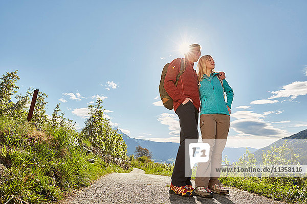 Mature couple hiking along country road  Meran  South Tyrol  Italy