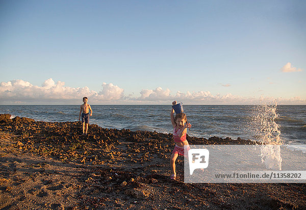 Mädchen rennt vor der plätschernden Welle am Strand weg  Blowing Rocks Preserve  Jupiter Island  Florida  USA