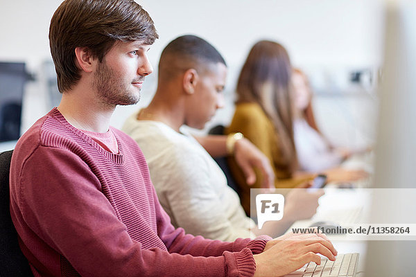 Studenten beim Tippen am Computer im Computerraum der Hochschule