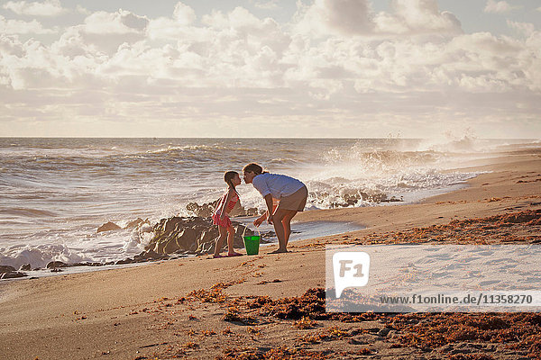 Reife Frau und Tochter schmusen für einen Kuss am Strand  Blowing Rocks Preserve  Jupiter Island  Florida  USA