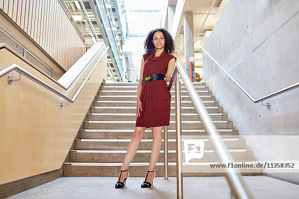 Porträt einer jungen Geschäftsfrau  die auf einer Bürotreppe steht