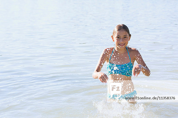 Girl running and splashing in Lake Seeoner See  Bavaria  Germany