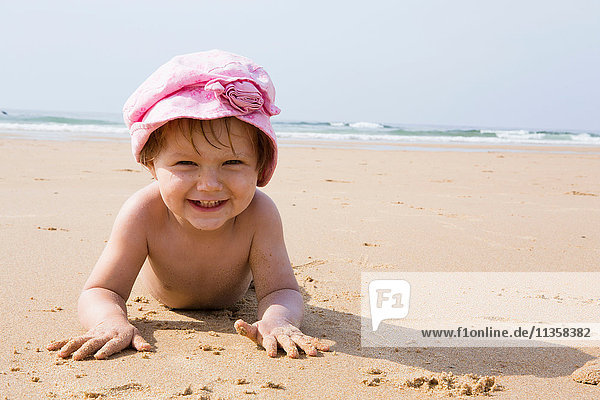 Porträt eines weiblichen Kleinkindes am Strand liegend  Sagres  Algarve  Portugal