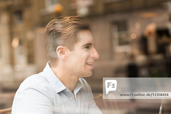 Window view of young businessman in cafe