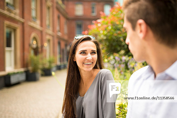 Young businesswoman and man talking outside office  London  UK