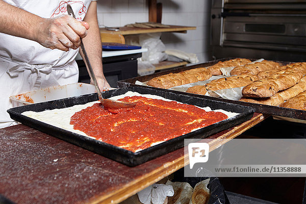 Baker working in bakery  mid section