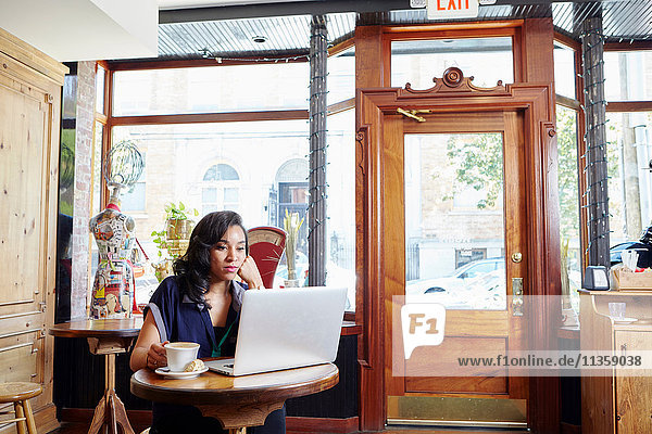 Young woman sitting in cafe  using laptop
