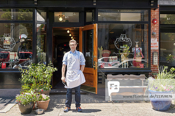 Portrait of male worker  standing outside bakery