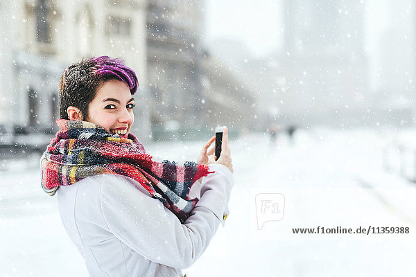 Portrait of young woman standing in front of the Christian Science Centre and Prudential building with snow Boston Massachusetts USA
