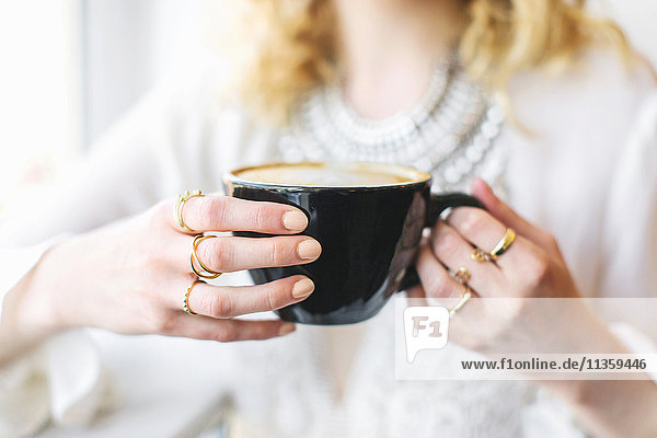 Cropped view of woman holding coffee cup