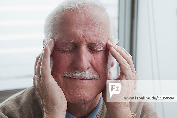 Älterer Mann leidet unter Kopfschmerzen