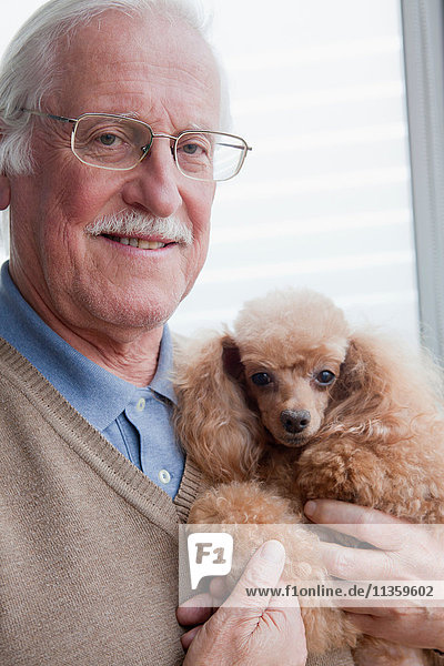 Senior Mann mit Haustier Hund zu Hause