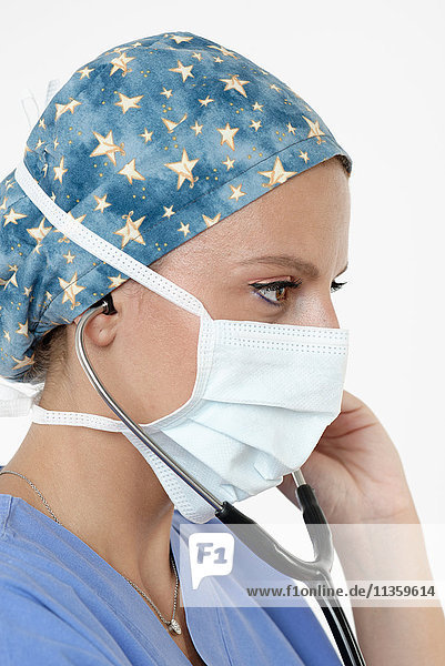 Chirurg mit chirurgischer Kappe  Maske und Stethoskop schaut weg