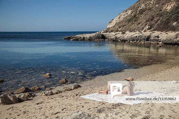 Junge Frau beim Sonnenbaden am Strand  Villasimius  Sardinien  Italien