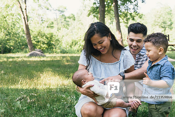 Eltern kauern mit Kleinkind und kleinem Sohn im Pelham Bay Park, Bronx, New York, USA