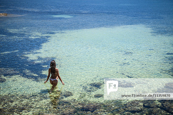 High angle view of young woman paddling in sea  Villasimius  Sardinia  Italy
