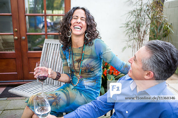 Älteres lachendes Paar auf der Terrasse bei Gartenparty