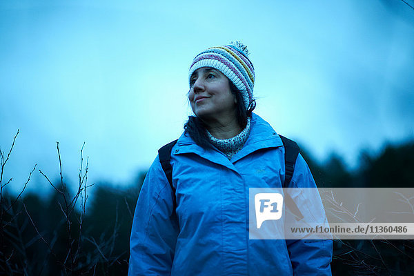 Female hiker hiking in forest at dusk