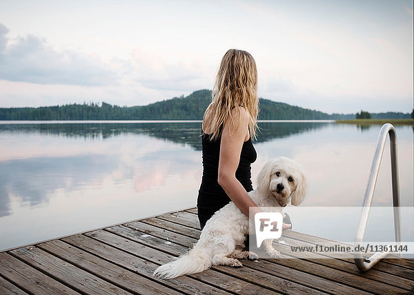Frau mit coton de tulear Hund am Seepier  Orivesi  Finnland