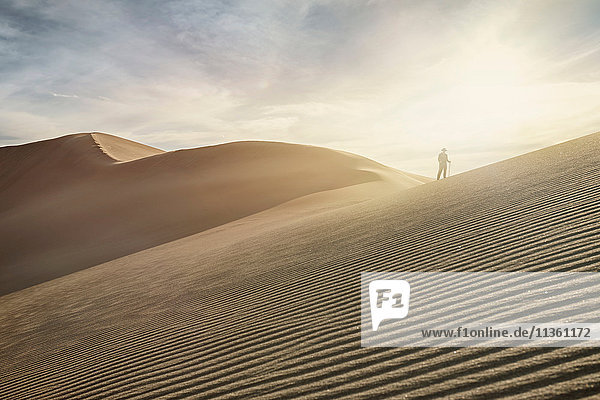 Silhouetted woman on top of dune at Great Sand Dunes National Park Colorado USA