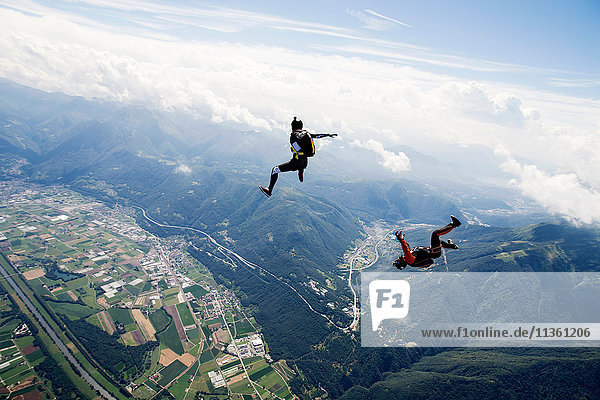 Freestyle Skydiving Team trainiert gemeinsam. Ein Mann führt Luftballett auf,  ein anderer Springer filmt mit Videokamera am Helm,  Locarno,  Tessin,  Schweiz