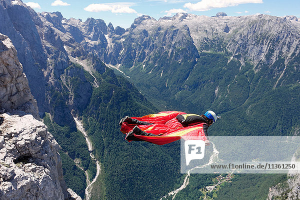 Wingsuit-BASE-Springer beim Fliegen entlang der Klippe und talwärts  Italienische Alpen  Alleghe  Belluno  Italien