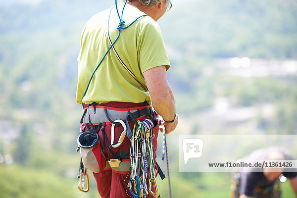 Rear view of rock climber wearing safety harness