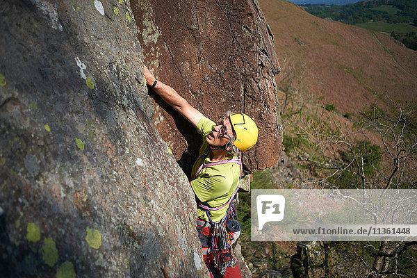 High angle view of rock climber climbing rock face