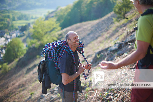 Rock climbers on hillside chatting and smiling
