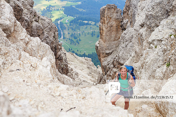 Frau wandert den Berg hinauf und schaut lächelnd in die Kamera  Österreich