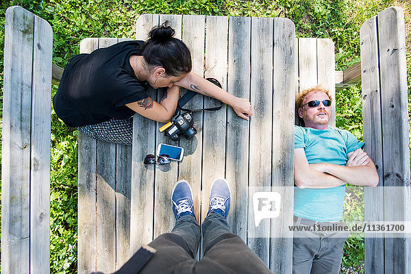 Draufsicht-Aufnahme eines auf einer Picknick-Bank ruhenden Paares