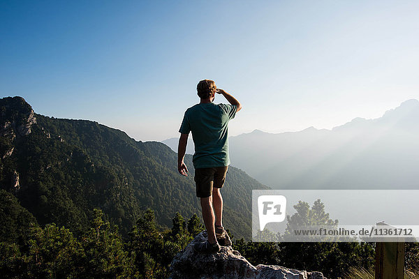 Rear view of man standing on mountain peak looking away  Passo Maniva  Italy