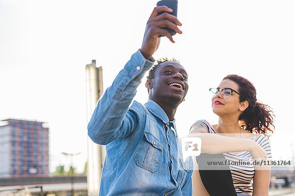 Couple using smartphone to take selfie  Milan  Italy