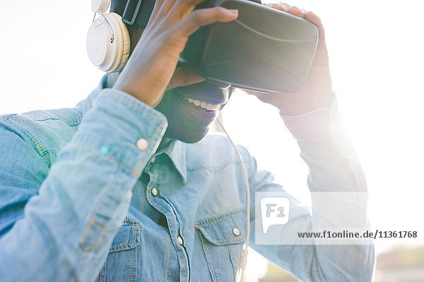 Man wearing virtual reality and headphones smiling