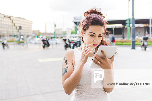 Frau im Stadtgebiet mit digitalem Tablett