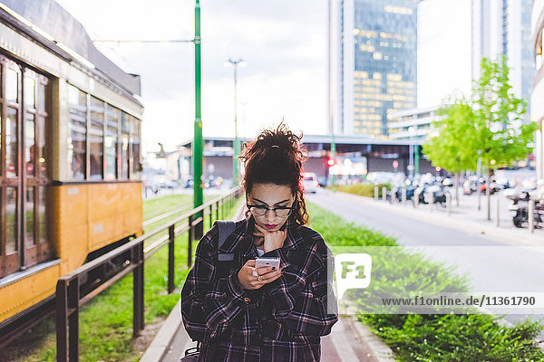 Frau SMS auf Smartphone im Stadtgebiet  Mailand  Italien