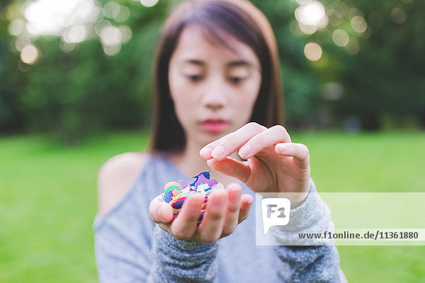 Young woman in park holding a handful of confetti