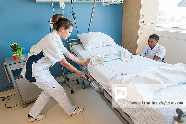 Krankenpfleger beim Einstellen von Krankenhausbetten