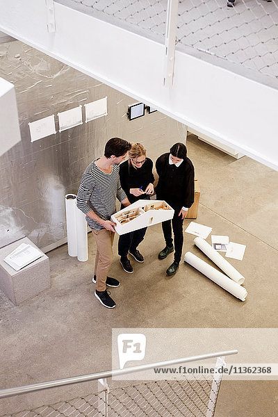 Architects in office looking at architectural model