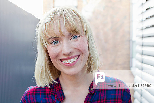 Portrait of blonde haired woman looking at camera smiling