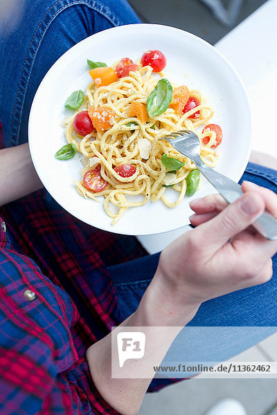 Cropped view of woman holding bowl of pasta