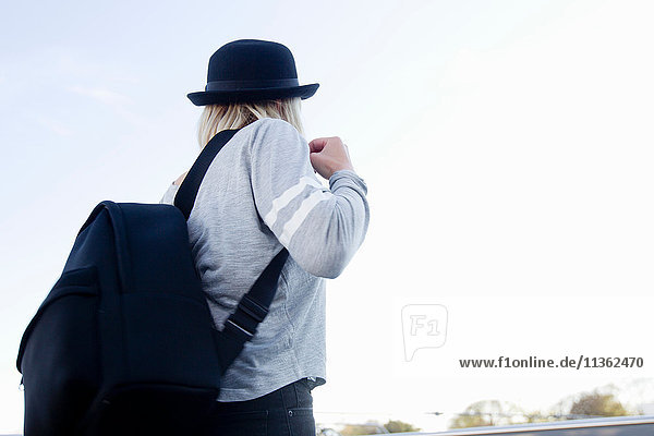 Rückansicht einer Frau mit Hut und Rucksack