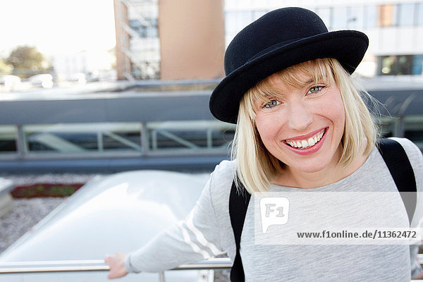 Portrait of blonde haired woman wearing hat looking at camera smiling