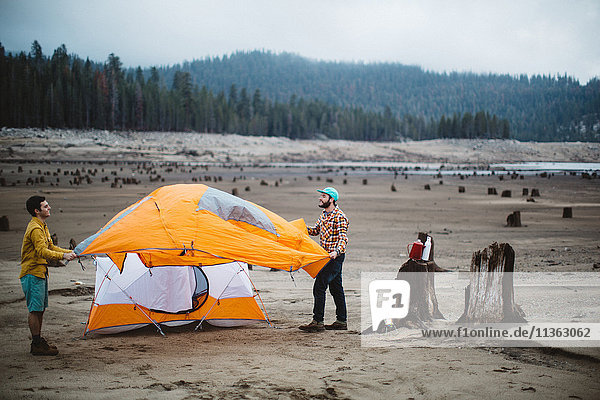 Zwei junge Männer bauen ihr Zelt am Strand auf  Huntington Lake  Kalifornien  USA