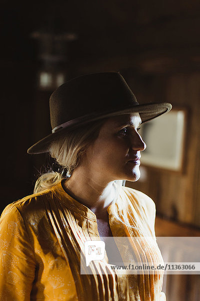 Portrait of woman in cabin  wearing cowboy hat