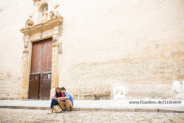 Ehepaar benutzt Mobiltelefon auf dem Bürgersteig  Palma de Mallorca  Spanien