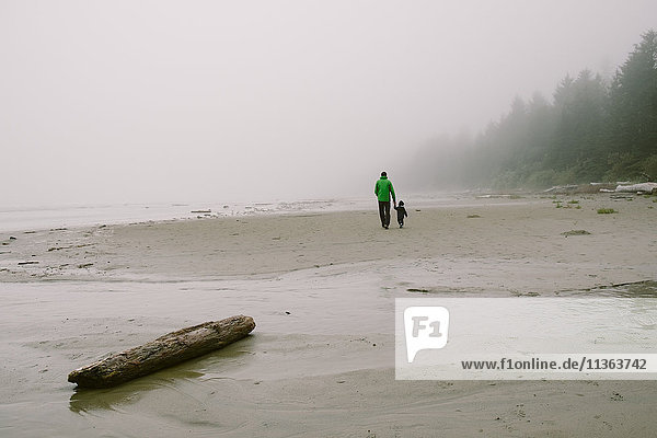 Vater und Sohn gehen am Strand spazieren  Rückansicht  Long Beach  Vancouver Island  British Columbia  Kanada